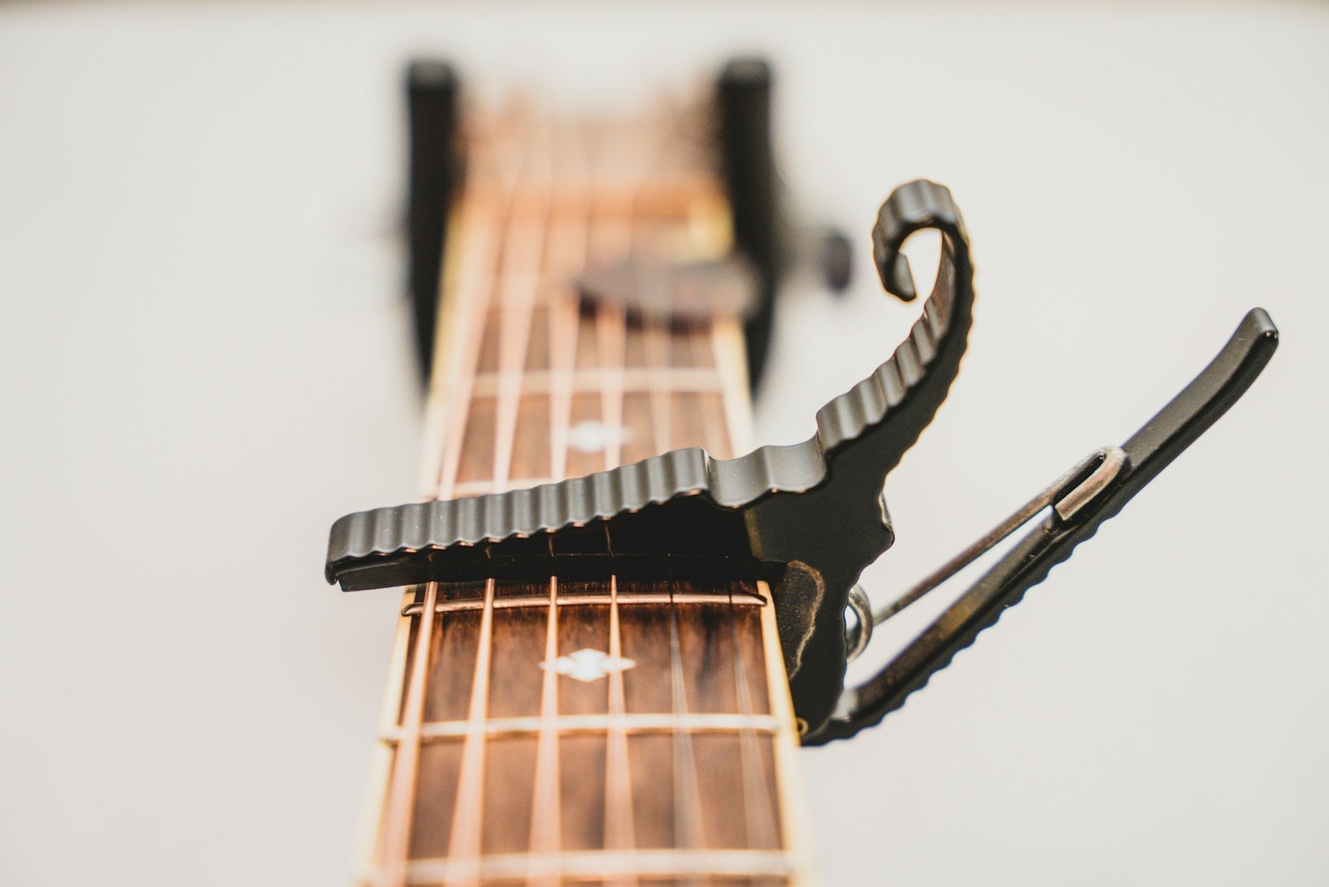 a-close-up-of-a-guitars-neck-with-a-capo